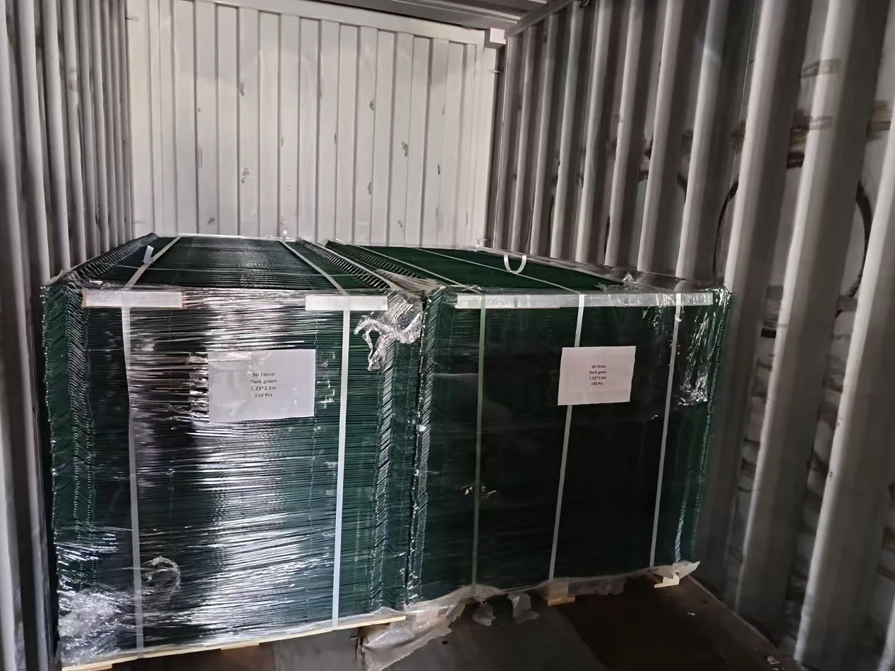 two wrapped dark-green 3D fence panel bundles with product labels inside a shipping container
