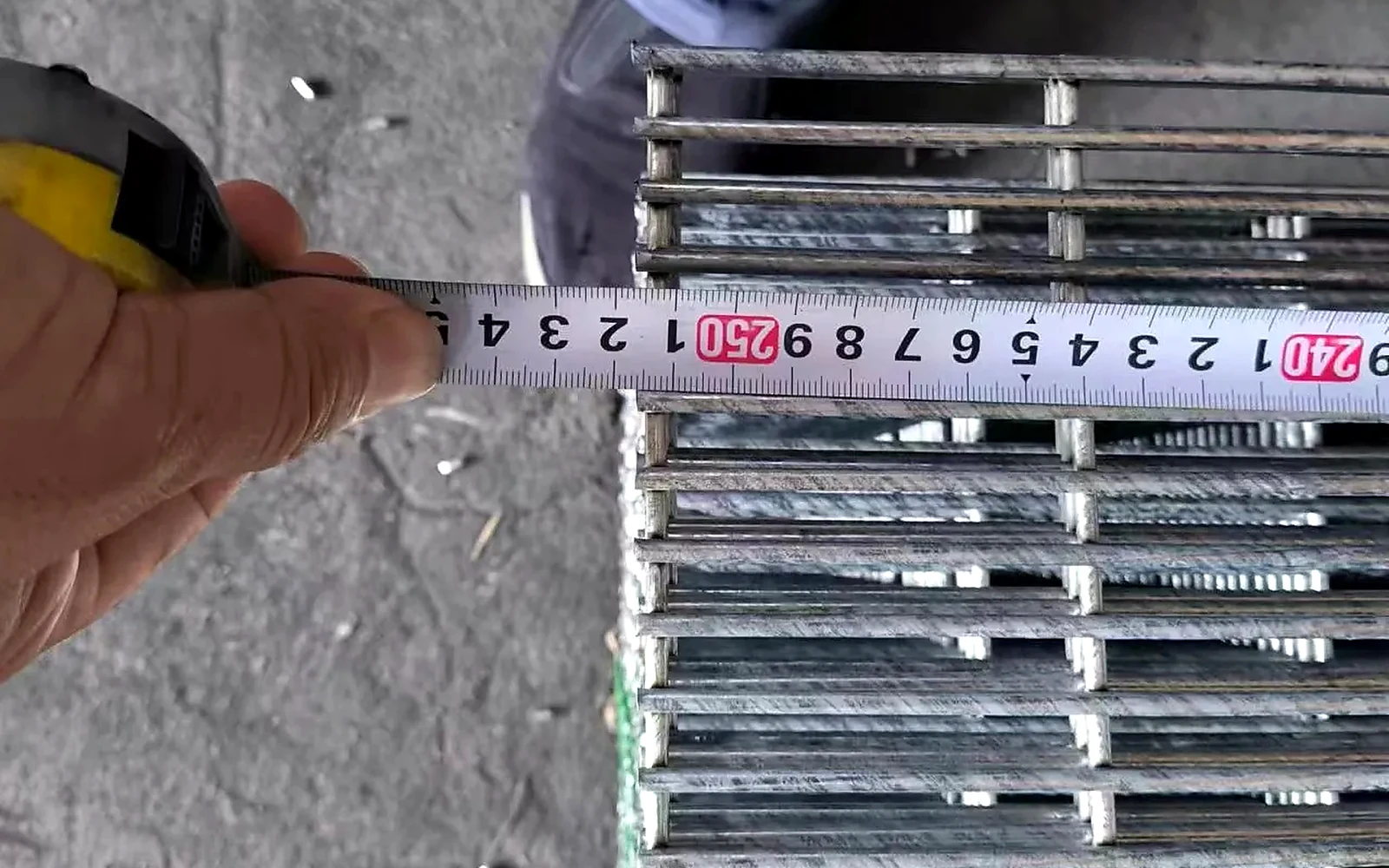 tape measure placed across stacked welded wire panels for a dimensional check