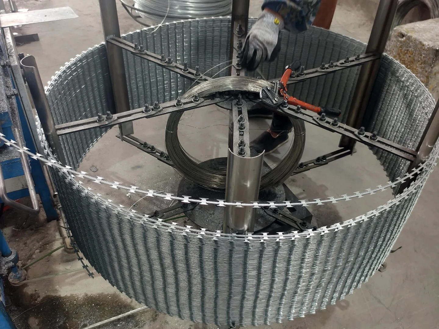 concertina razor wire being formed around a circular coiling fixture