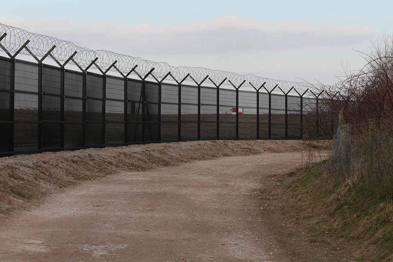 representative airport perimeter security fence application with rigid panels and concertina topping