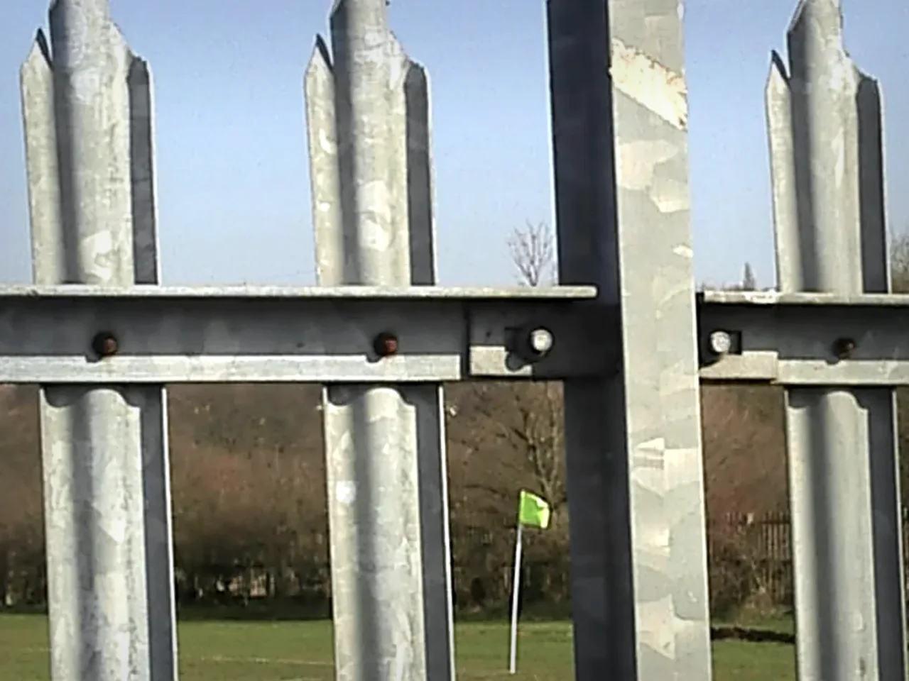 close-up of galvanized steel palisade fence pales rail and bolts